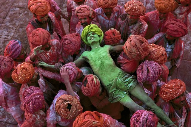 Holi festival, Rajasthan, India, 1996 The Holi festival is also known as the festival of colours and this image by McCurry shows why. With powder bombs exploding around him, this man is in a state of reverie as he is carried aloft through the crowd. In form and content it is an image of intense fervour and excitement. Magnum Photos, NYC94205, MCS1996002K308 final print_MACRO'11 Phaidon Iconic_Book